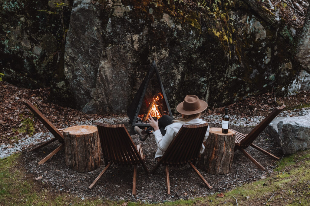 Person sitting by an outdoor fire pit.
